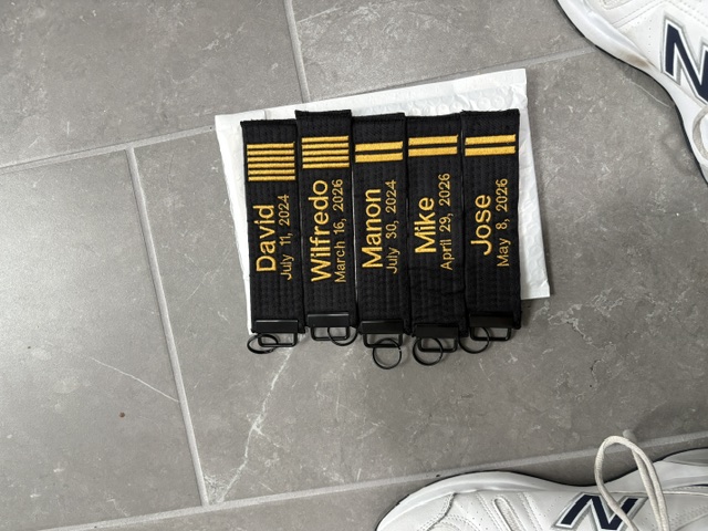 Black belt key chains presented by David J. Ellis at the July 2, 2026 Black Belt Ceremony and Celebration